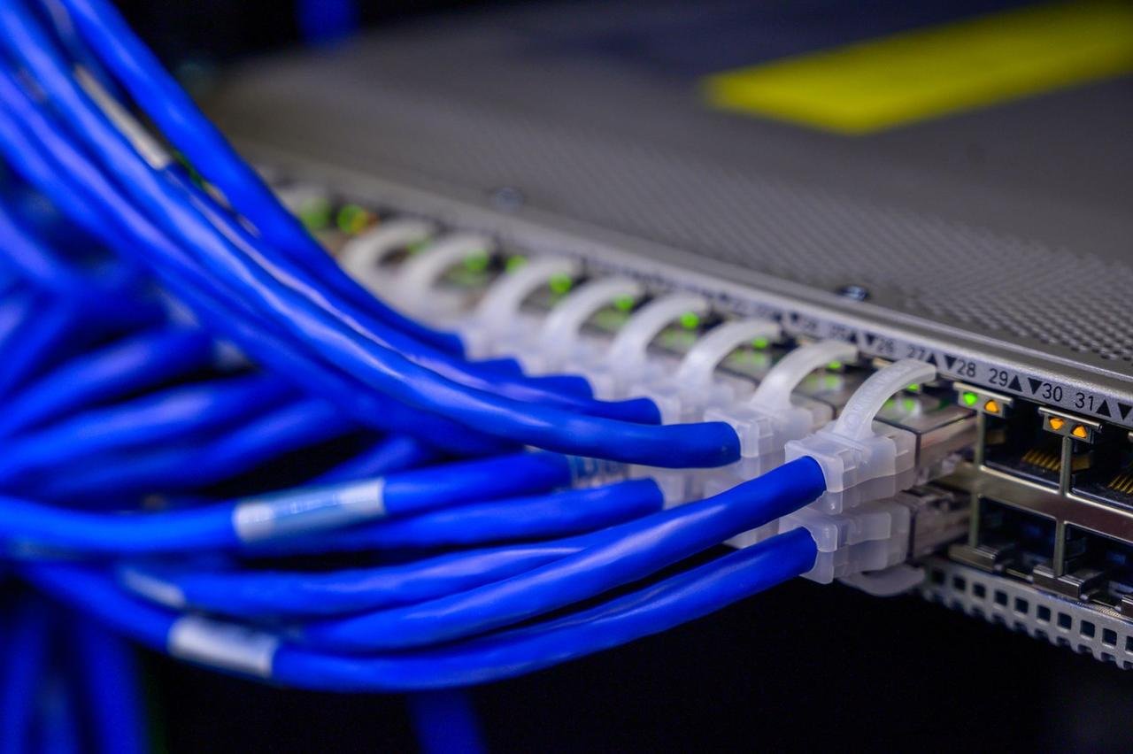 Blue, yellow, and red ethernet cables plugged into a network switch